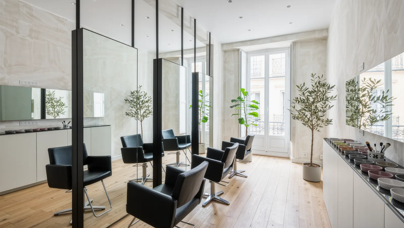 Le salon : trois fauteuils face à de grands miroirs, lumière du jour
